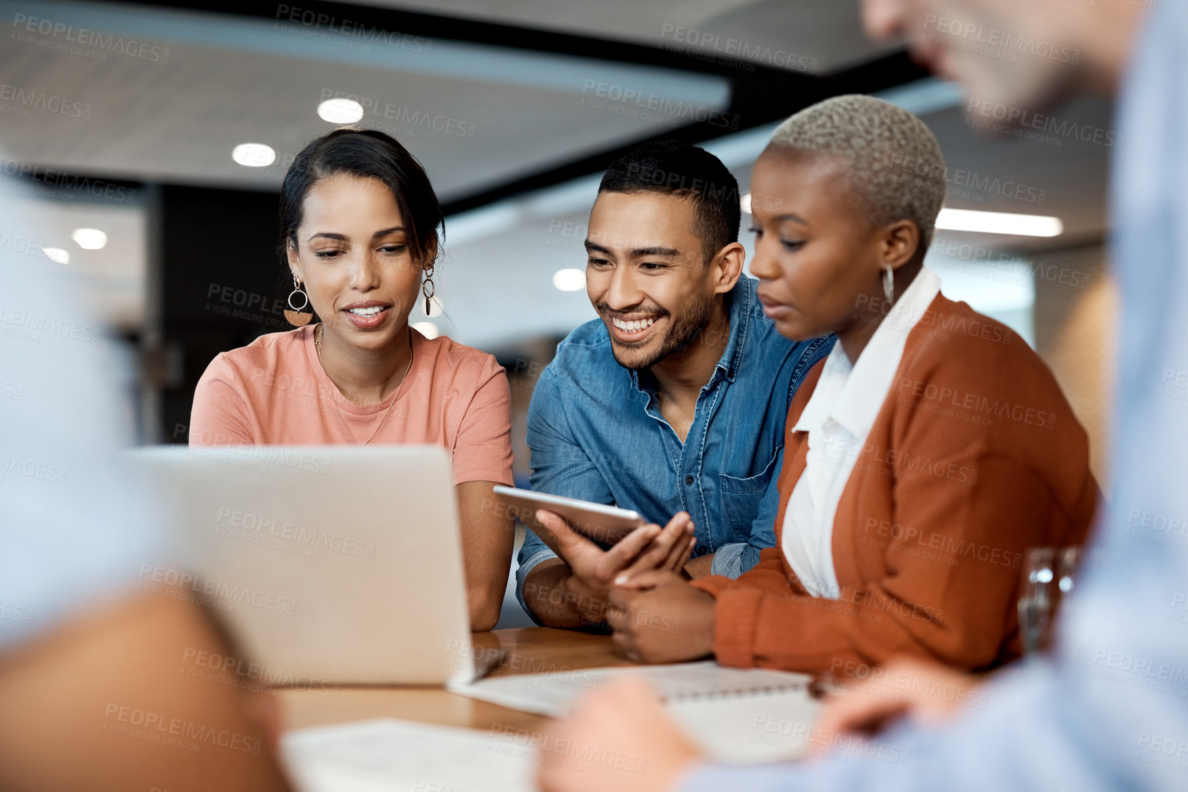 Buy stock photo Shot of a group of young businesspeople using a laptop at a conference in a modern office