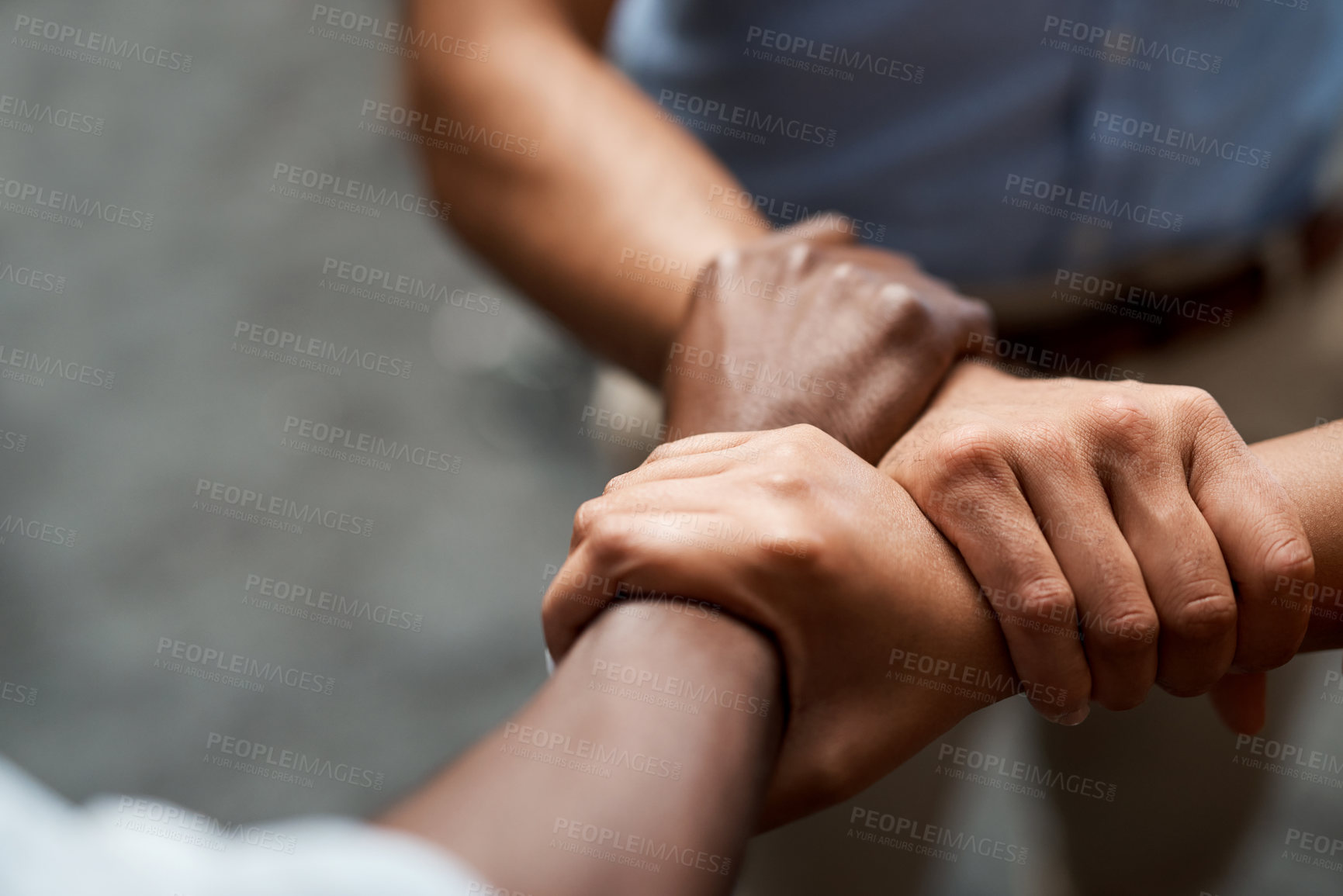 Buy stock photo Shot of a group of businesspeople linking arms in solidarity in a modern office