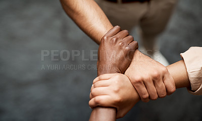 Buy stock photo Shot of a group of businesspeople linking arms in solidarity in a modern office