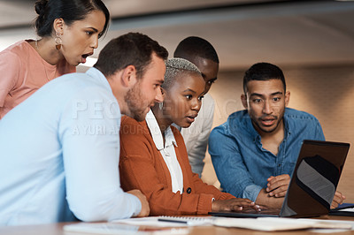 Buy stock photo Shot of a group of young businesspeople using a laptop at a conference in a modern office