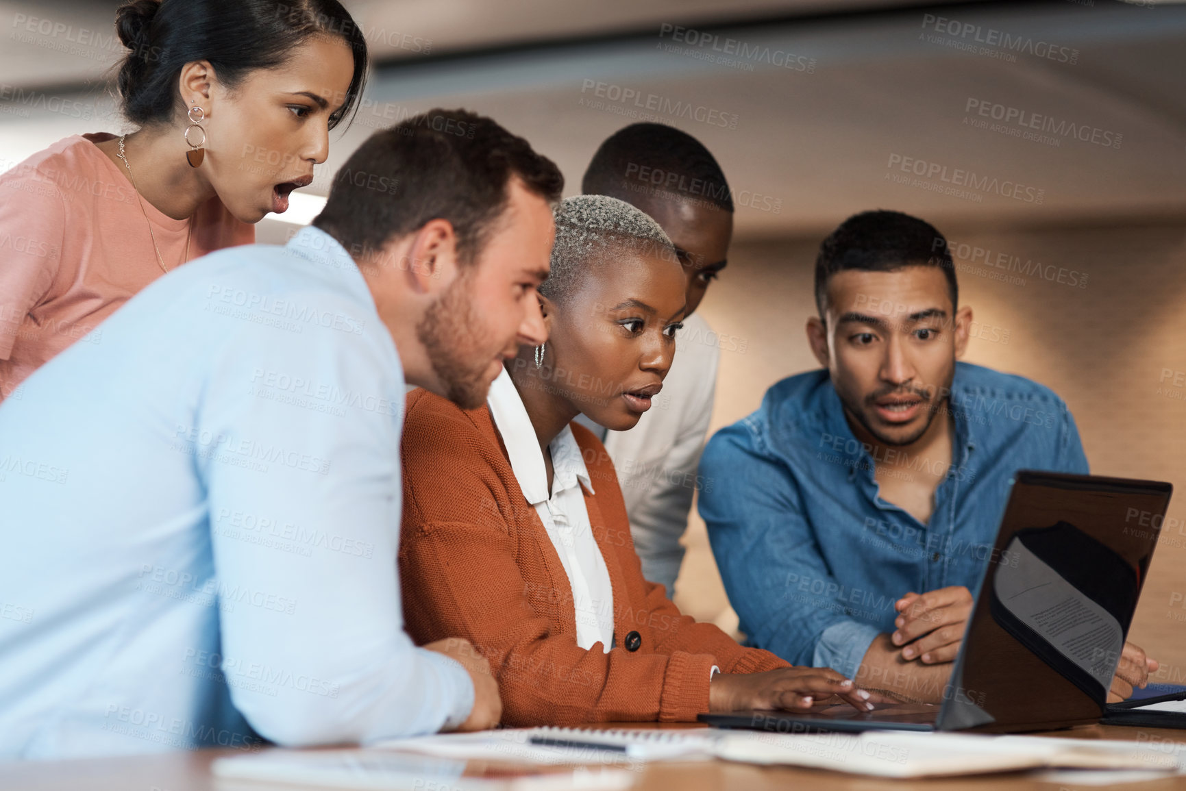 Buy stock photo Shot of a group of young businesspeople using a laptop at a conference in a modern office