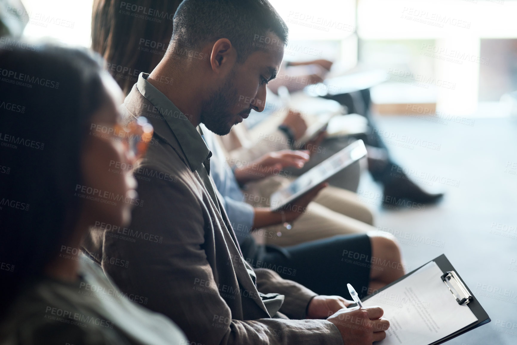 Buy stock photo Shot of a group of businesspeople taking notes during a meeting in an office