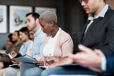 Buy stock photo Shot of a group of businesspeople making notes during a conference in a modern office