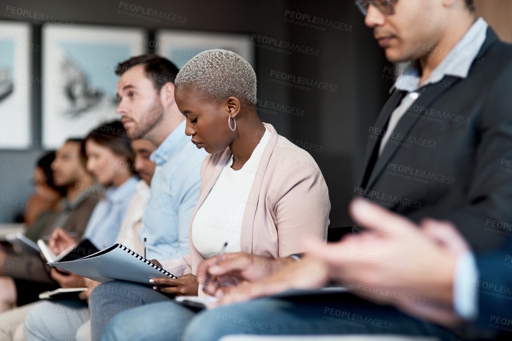 Buy stock photo Shot of a group of businesspeople making notes during a conference in a modern office