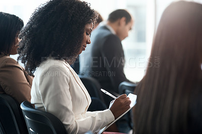 Buy stock photo Shot of a group of businesspeople taking notes during a meeting in an office