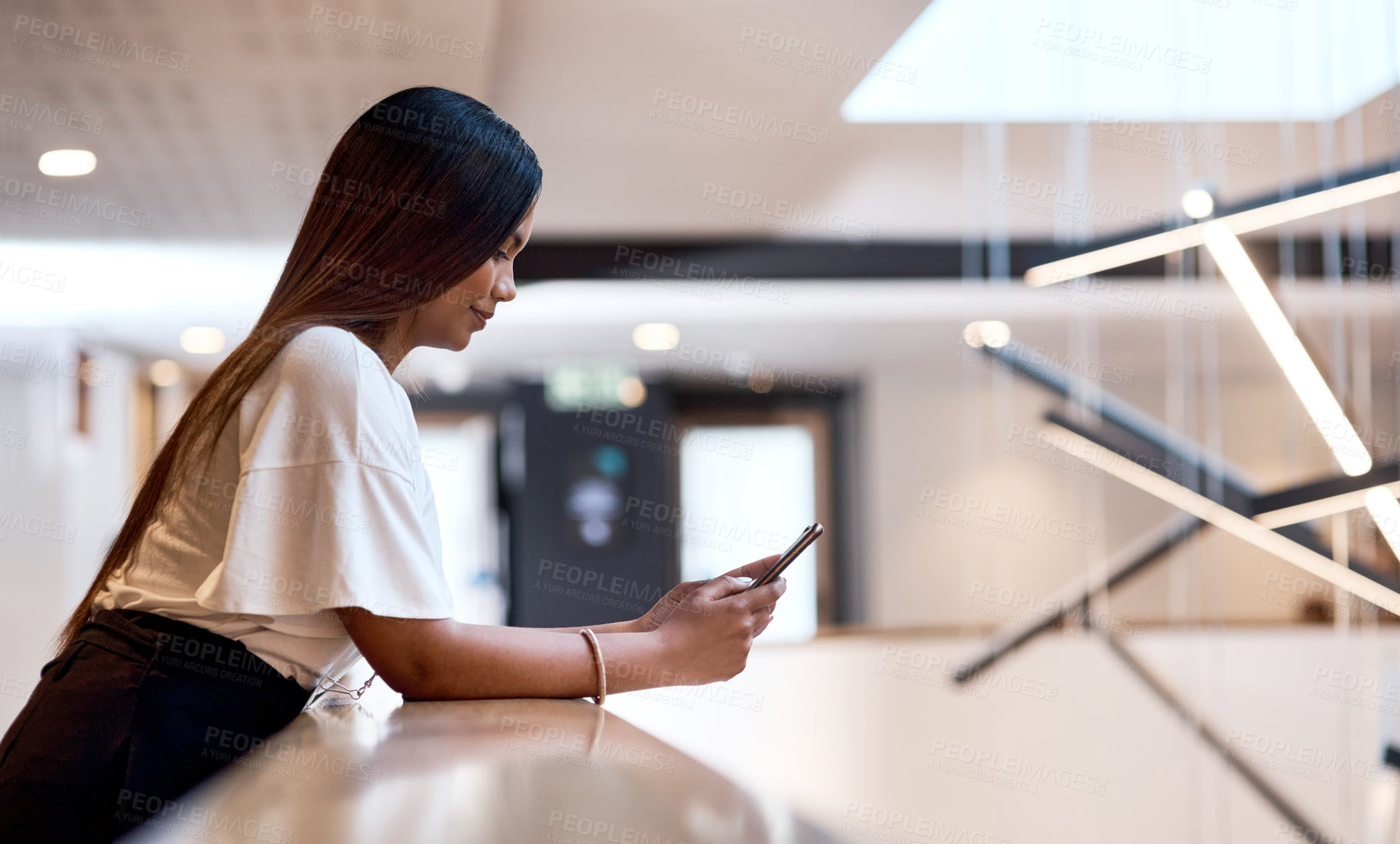 Buy stock photo Shot of a young businesswoman using a smartphone at a conference