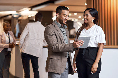 Buy stock photo Shot of a young businessman and businesswoman using a digital tablet at a conference