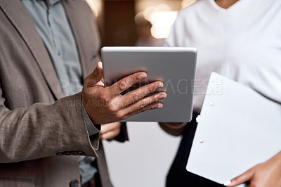 Buy stock photo Shot of a businessman and businesswoman using a digital tablet at a conference