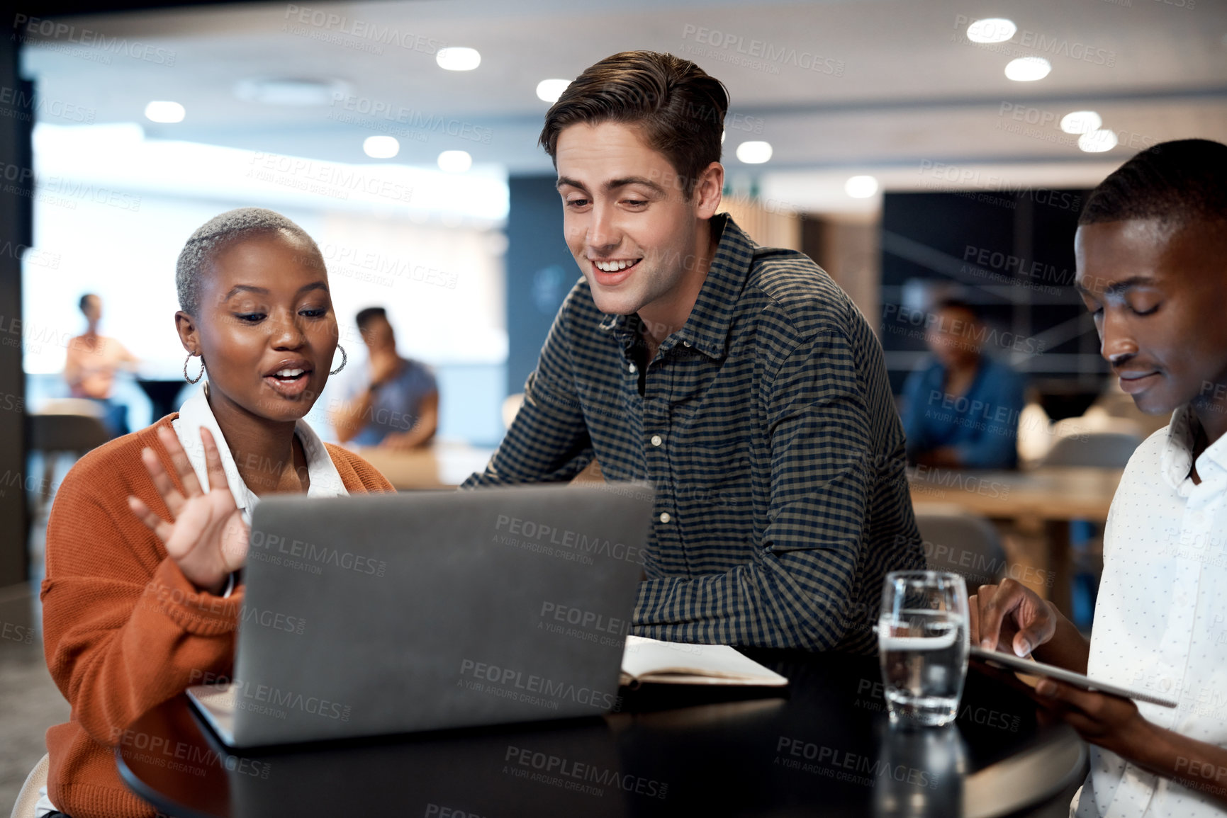 Buy stock photo Shot of a group of young businesspeople using a laptop during a conference in a modern office