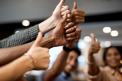 Buy stock photo Shot of a group of unrecognisable businesspeople showing thumbs up in a modern office