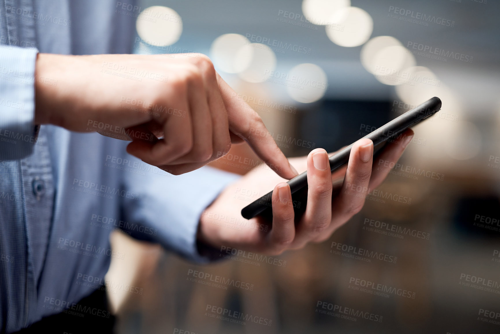 Buy stock photo Shot of an unrecognisable businessman using a smartphone in a modern office