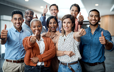 Buy stock photo Portrait of a group of young businesspeople showing thumbs up in a modern office