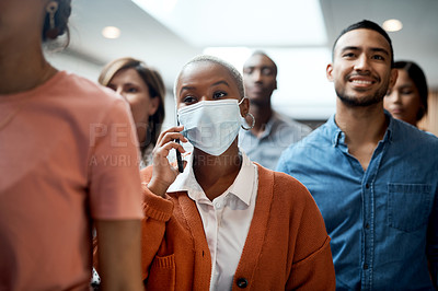 Buy stock photo Shot of a masked young businesswoman using a smartphone during a conference