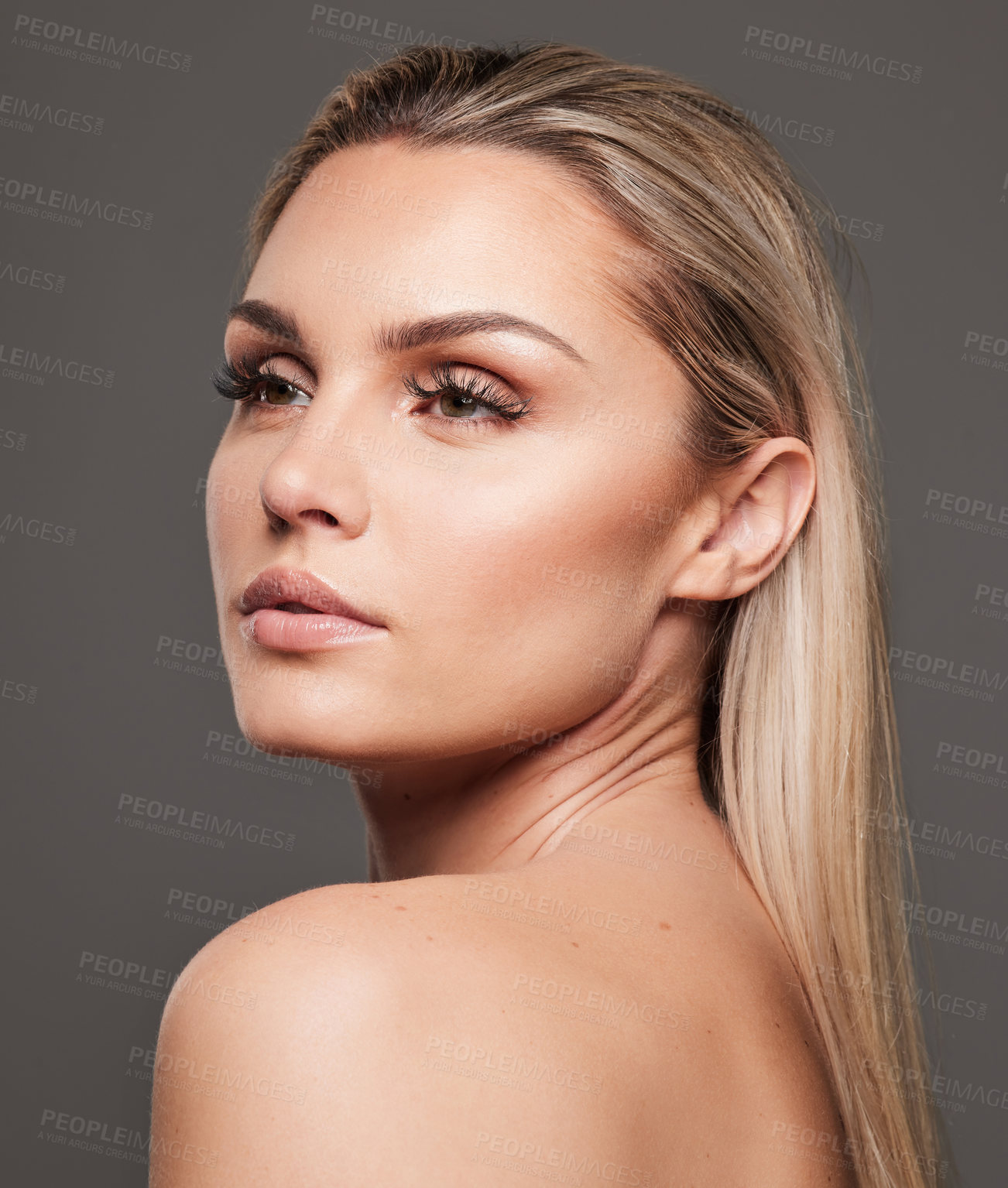 Buy stock photo Studio shot of a beautiful young woman standing against a grey background