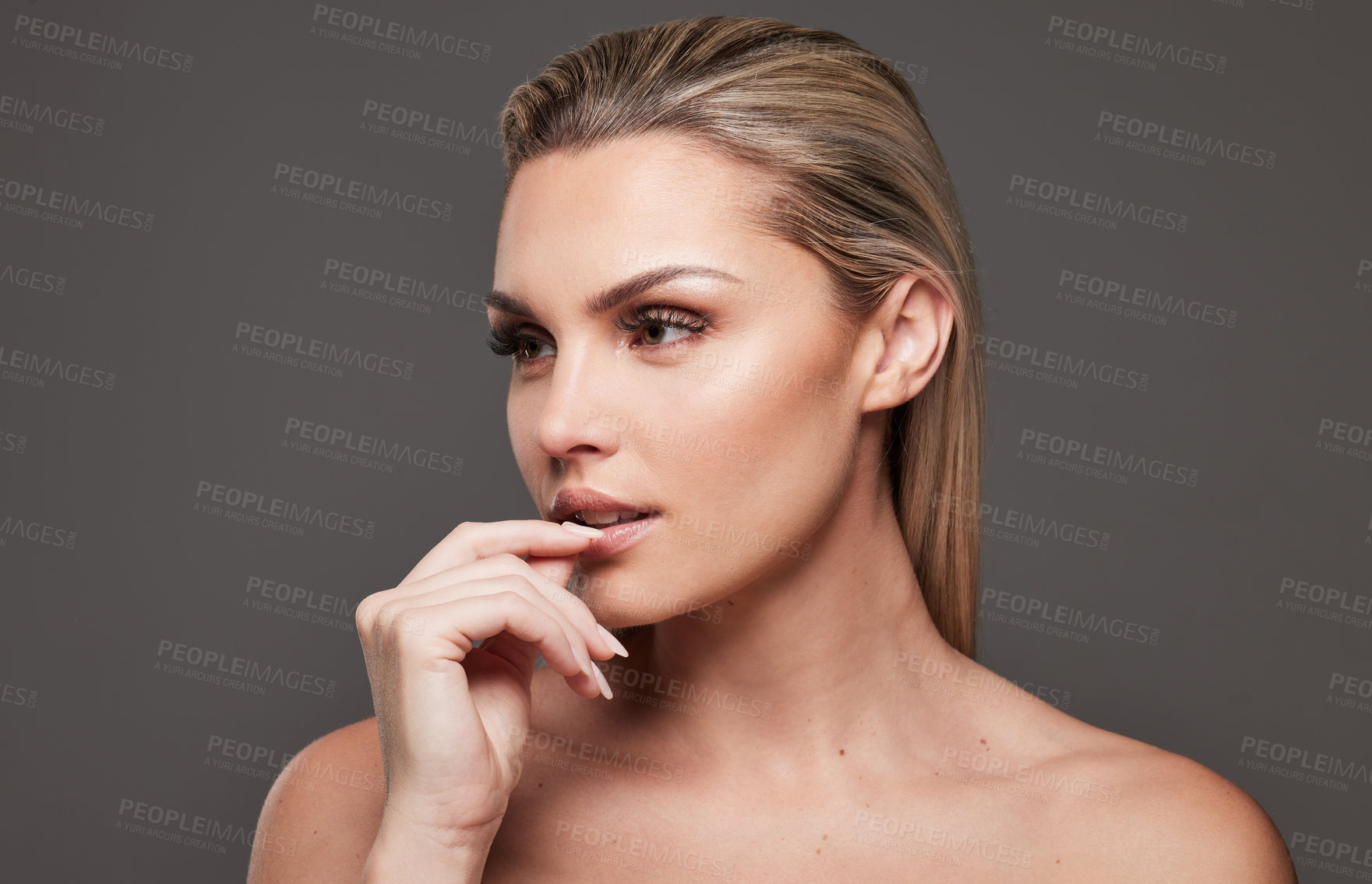 Buy stock photo Studio shot of a beautiful young woman standing against a grey background