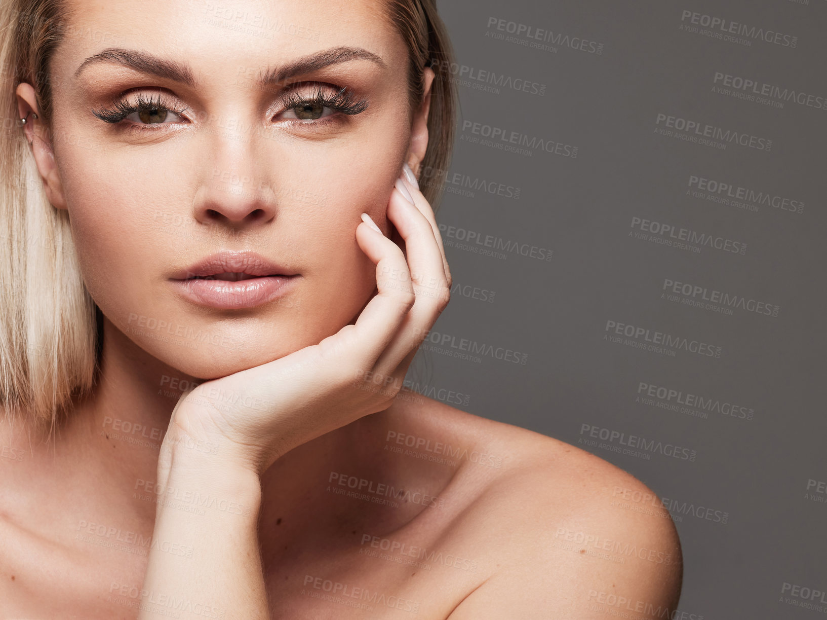 Buy stock photo Studio shot of a beautiful young woman standing against a grey background