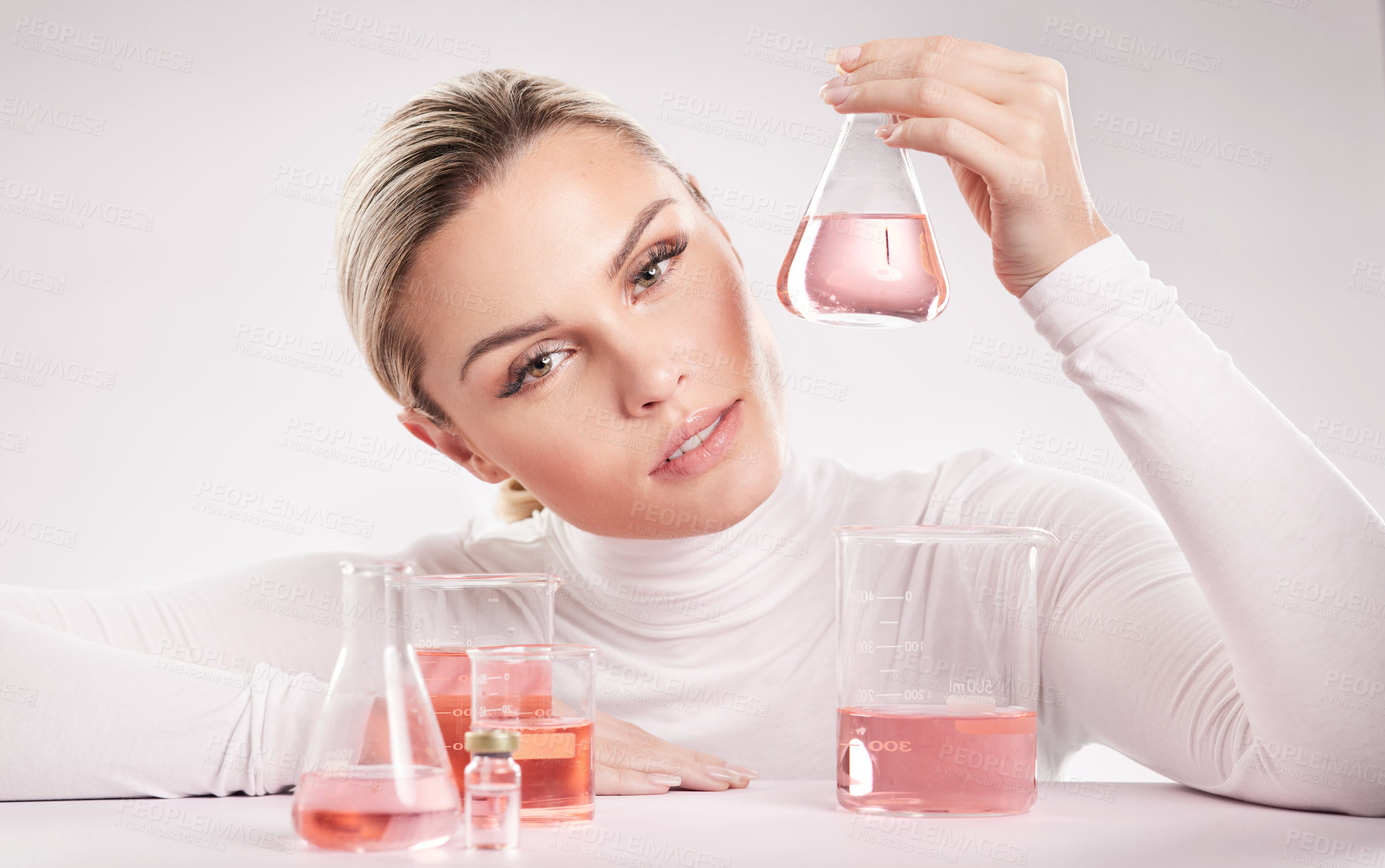 Buy stock photo Studio shot of  young woman making a potion against a white background