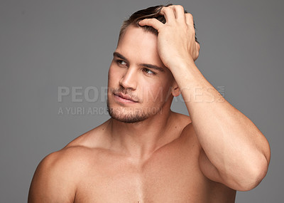 Buy stock photo Studio shot of a handsome young man posing against a grey background