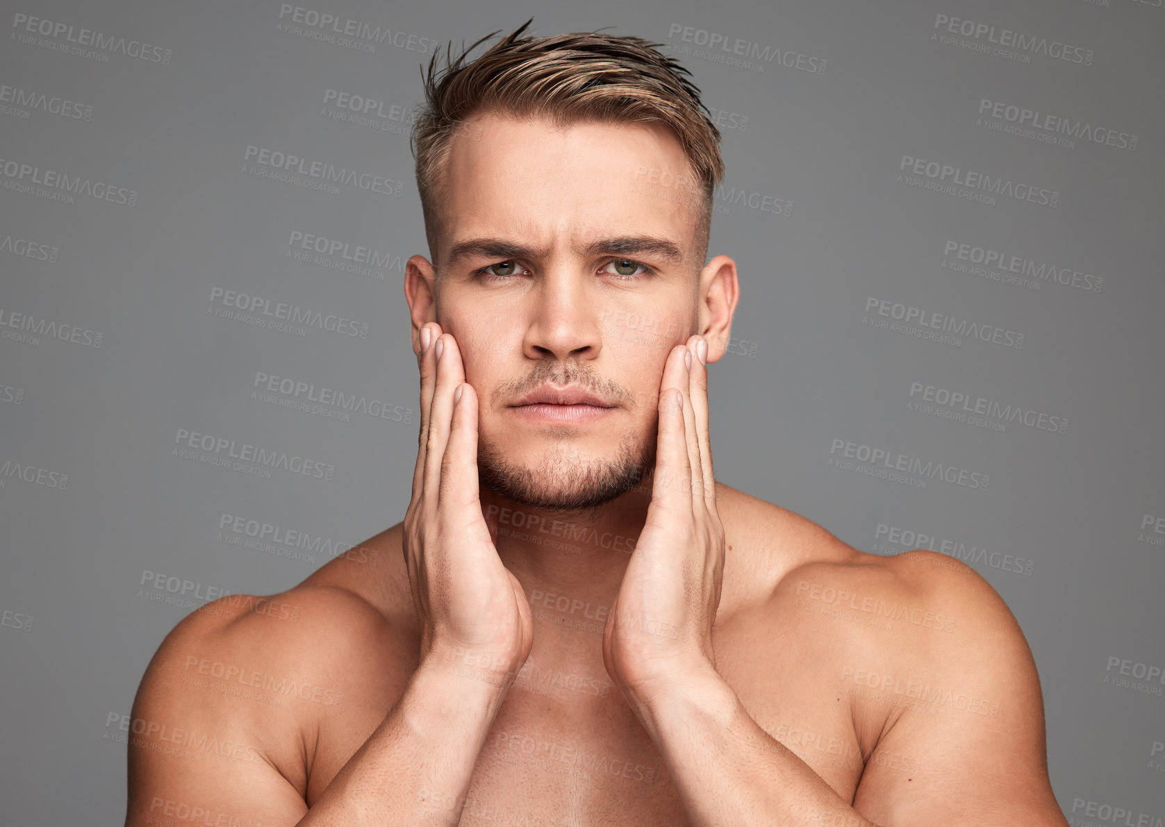 Buy stock photo Studio shot of a handsome young man posing against a grey background