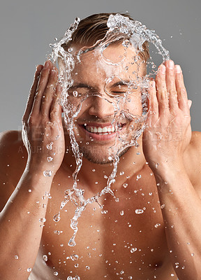 Buy stock photo Studio shot of a handsome young man washing his face against a grey background