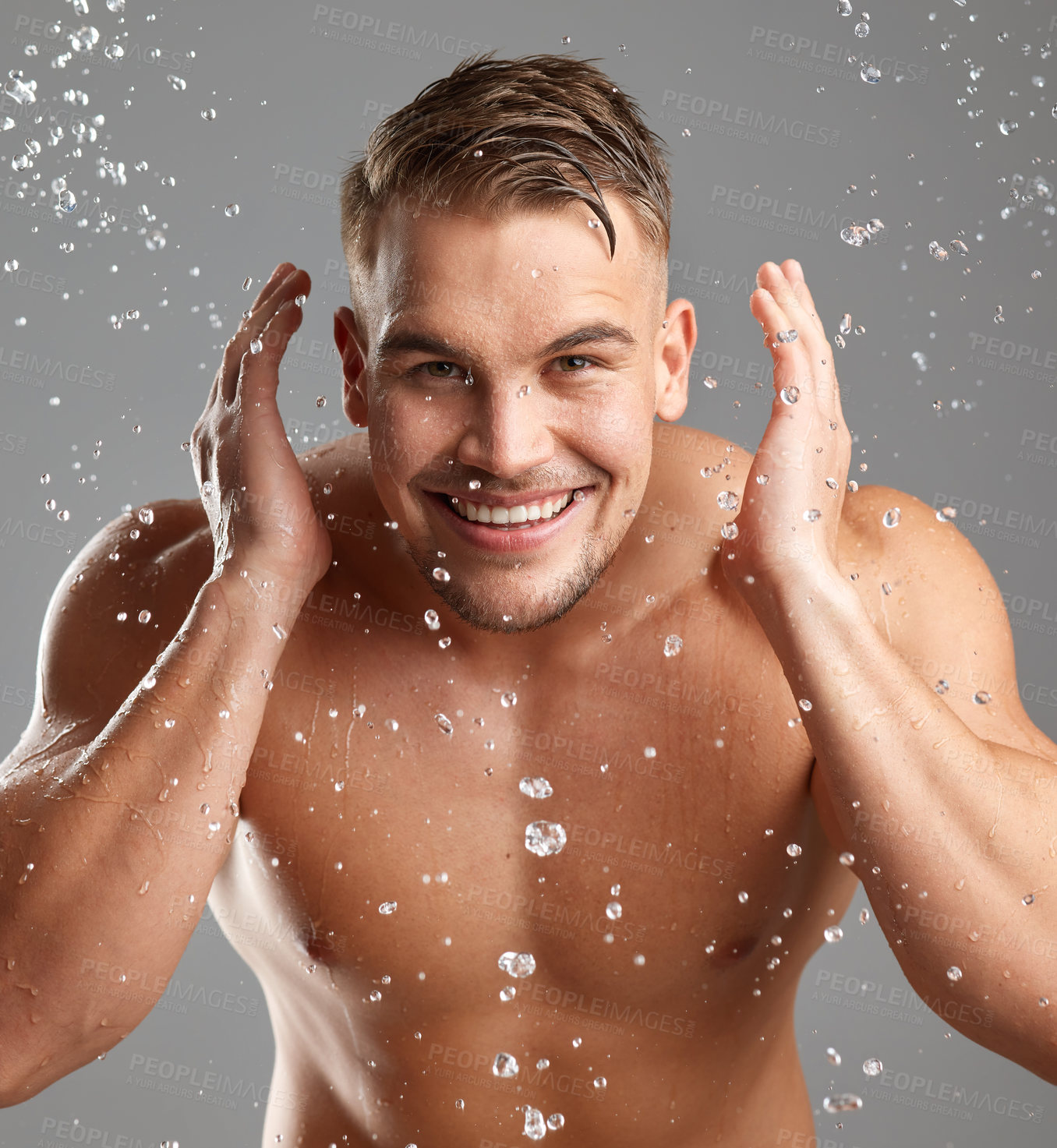 Buy stock photo Studio shot of a handsome young man washing his face against a grey background