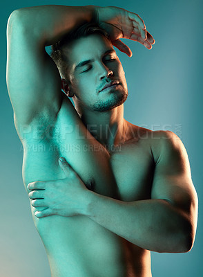 Buy stock photo Studio shot of a handsome young man posing against a blue background