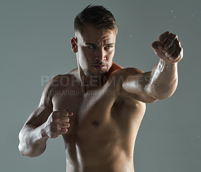 Buy stock photo Shot of a young man practicing  his punches against a studio background