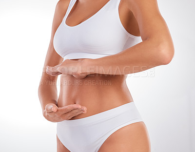 Buy stock photo Cropped shot of an unrecognizable woman standing in her underwear and posing in the studio