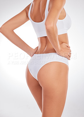 Buy stock photo Cropped shot of an unrecognizable woman standing in her underwear and posing in the studio