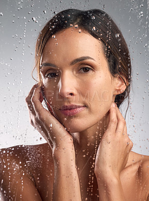 Buy stock photo Studio portrait of a beautiful young woman taking a shower against a grey background