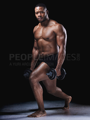 Buy stock photo Studio portrait of a fit young man exercising against a black background