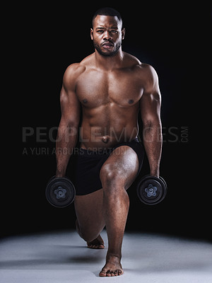 Buy stock photo Studio portrait of a fit young man exercising against a black background