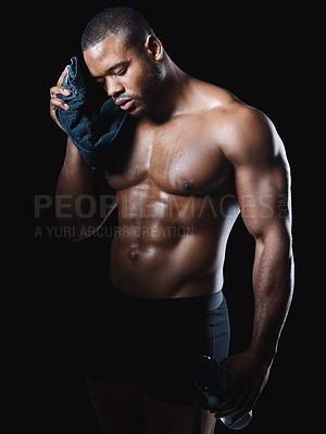 Buy stock photo Studio shot of a sweaty young man posing against a black background