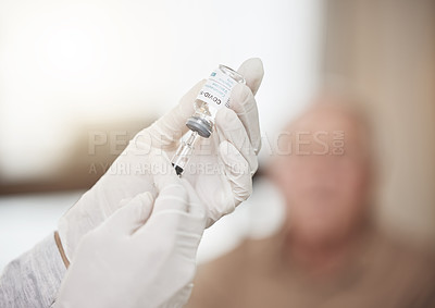 Buy stock photo Shot of an unrecognizable nurse extracting liquid from a vial with a syringe during a checkup at home