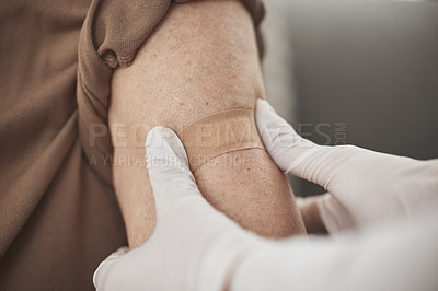 Buy stock photo Closeup shot of an unrecognizable nurse applying a bandaid to a patient's arm during a checkup at home