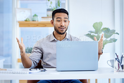 Buy stock photo Shot of a young businessman looking surprised while working on a laptop in an office