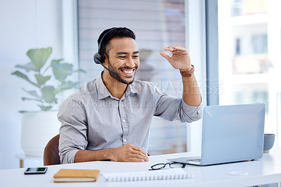 Buy stock photo Shot of a young businessman wearing a headset while working on a laptop in an office