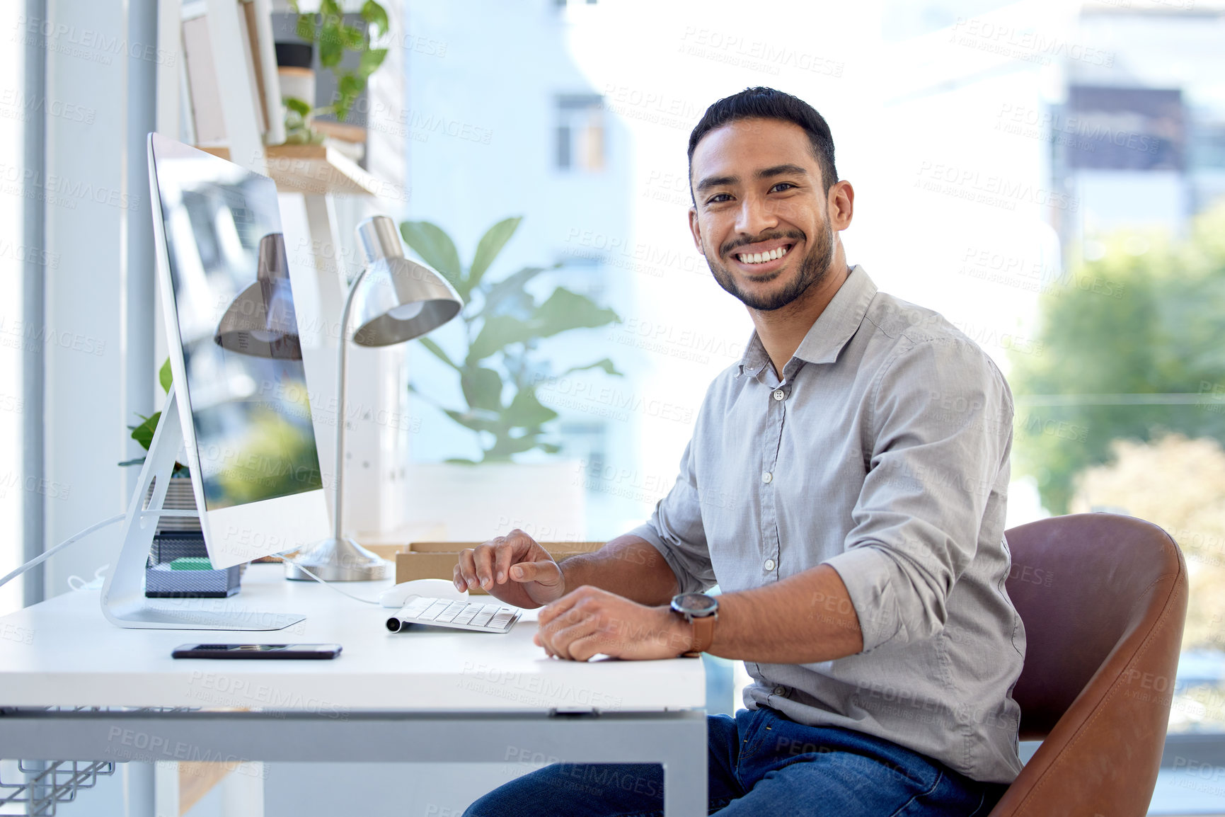 Buy stock photo Portrait of a young businessman working on a computer in an office