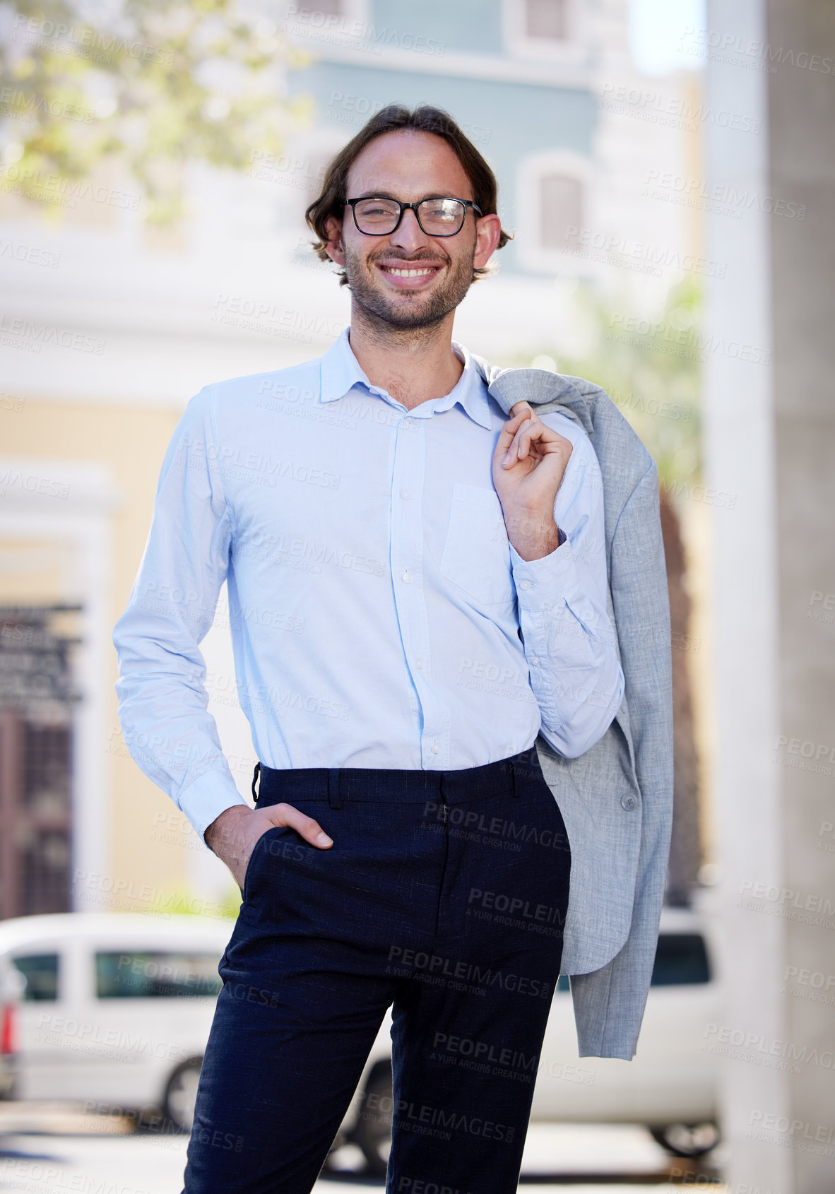 Buy stock photo Portrait of a young businessman standing with his jacket over his shoulder while out in the city