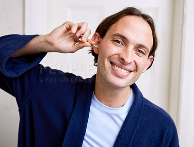 Buy stock photo Shot of a young man using an earbud to clean his ear