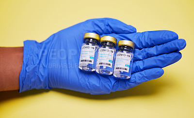 Buy stock photo Shot of an unrecognizable person holding vaccine tubes  against a yellow background