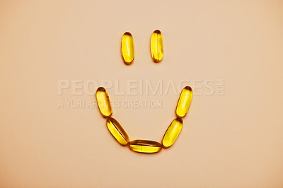 Buy stock photo Studio shot of pills forming a smiley face against an orange background