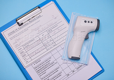 Buy stock photo Studio shot of a thermometer and clipboard against a blue background