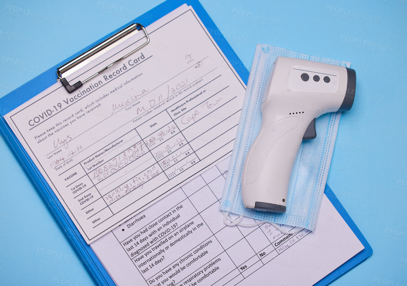 Buy stock photo Studio shot of a thermometer and clipboard against a blue background