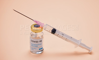 Buy stock photo Studio shot of a vaccine tube and syringe against an orange background