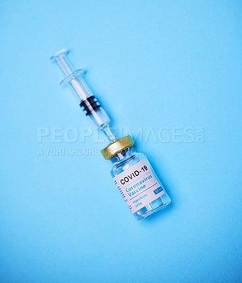 Buy stock photo Studio shot of a vaccine tube and syringe against a blue background