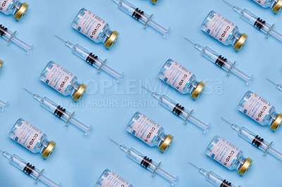 Buy stock photo Shot of vaccines and syringes against a blue background