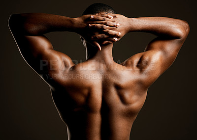 Buy stock photo Rearview studio shot of a fit young man posing against a black background