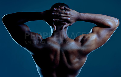 Buy stock photo Rearview studio shot of a fit young man posing against a black background