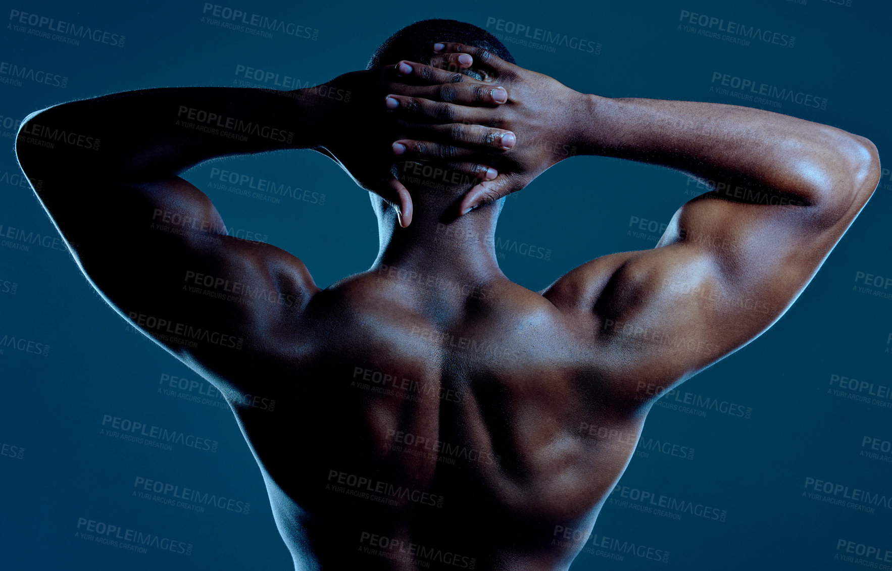 Buy stock photo Rearview studio shot of a fit young man posing against a black background